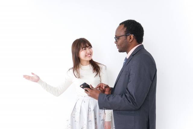 黒人男性を案内する日本人女性